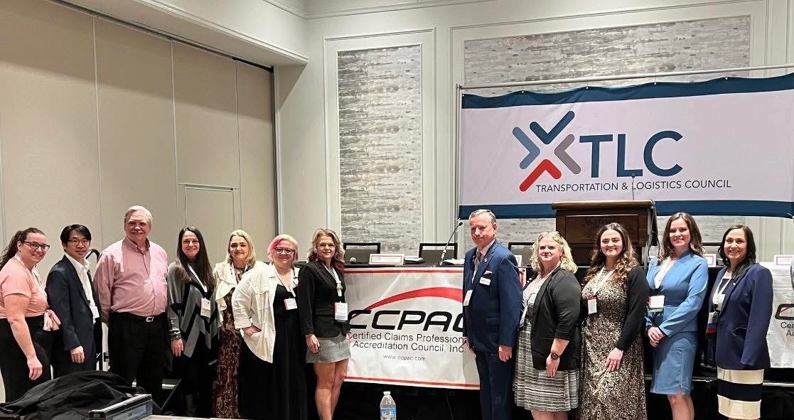 The CCPAC Board of Directors in front of the CCPAC banner